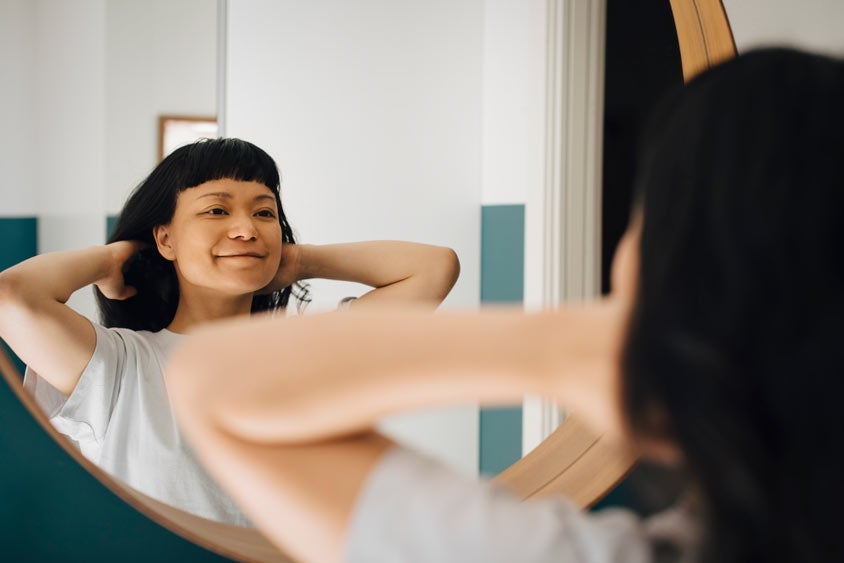 Woman staring at reflection in mirror